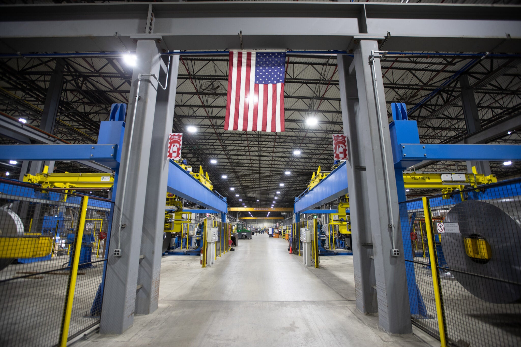 a steel pipe and tube manufacturing facility with an American flag hanging from a beam